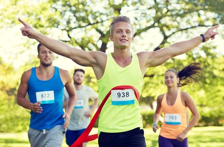 fitness, sport, victory, success and healthy lifestyle concept - happy man winning race and coming...