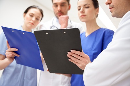 clinic, profession, people, healthcare and medicine concept - close up of doctors with clipboard at hospitalの写真素材