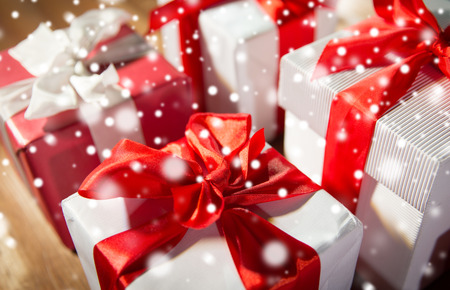 christmas, holidays, presents, new year and celebration concept - close up of gift boxes and red balls on wooden floorの写真素材