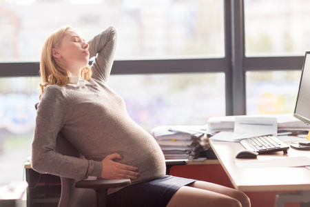 pregnancy, business, gestosis and people concept - pregnant businesswoman feeling sick at office workの写真素材