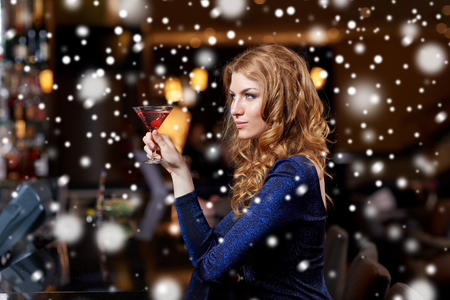 people, party, nightlife, drink and holidays concept - glamorous woman with cocktail at night club or barの写真素材