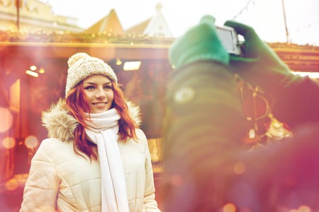 holidays, winter, christmas, technology and people concept - happy couple of tourists in warm...