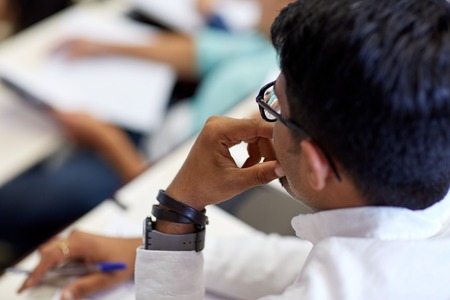 education, high school, university, learning and people concept - close up of indian student man at...