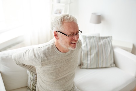people, healthcare and problem concept - unhappy senior man suffering from pain in back or reins at...