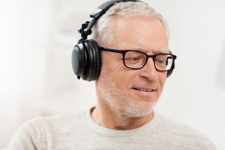 technology, people and lifestyle concept - close up of happy senior man in headphones listening to music at homeの写真素材