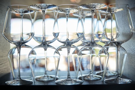 winery, glassware and alcohol concept - empty wine glasses set on shelf at restaurantの写真素材