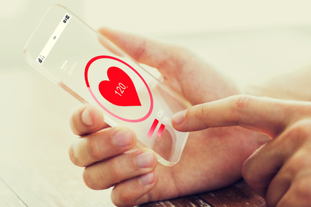medicine, healthcare, technology and people concept - close up of male hand holding and showing transparent smartphoneの写真素材