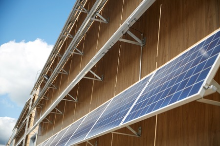 energy sources, power, environment and ecology concept - solar battery panels on building facade