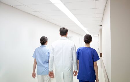 clinic, profession, people, healthcare and medicine concept - group of medics or doctors walking along hospital corridorの写真素材