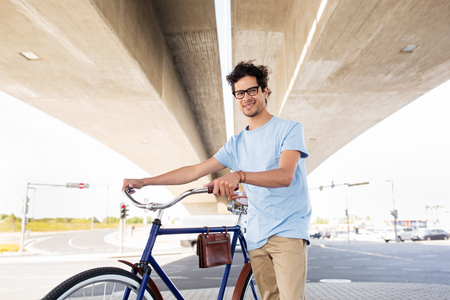 people, style, leisure and lifestyle - hipster man with fixed gear bike under city bridgeの写真素材