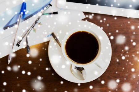 business and drinks concept - coffee cup, charts and tablet pc on table over snowの写真素材