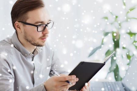 business, startup and people concept - businessman or creative male office worker with book or diary...