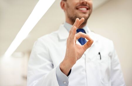 healthcare, gesture, people and medicine concept - close up of happy male doctor at hospital showing ok hand signの写真素材
