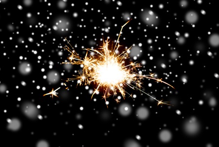 christmas, holidays, new year party and pyrotechnics concept - sparkler or bengal light burning over...
