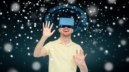 technology, augmented reality, winter, christmas and people concept - happy young man with virtual...