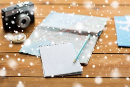 vacation, tourism, travel, winter holidays and objects concept - close up of blank notepad with map and airplane ticketsの写真素材