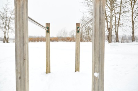 fitness, sport, exercising, training and equipment concept - parallel bars outdoors in winter