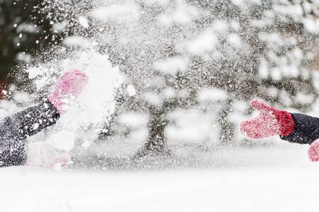 people, season, winter holidays and christmas concept - happy friends playing with snow outdoorsの写真素材