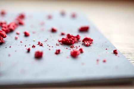 food and cooking concept - dried raspberries or berries on stone plate