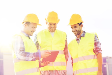 business, building, teamwork, technology and people concept - group of smiling builders in hardhats...