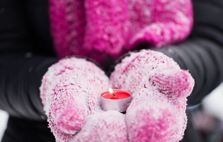 winter holidays, christmas and people concept - close up of hands in mittens holding burning tea...