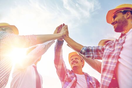 business, building, partnership, gesture and people concept - close up of smiling builders and...