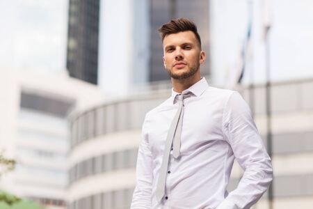 business and people concept - young man in shirt and tie on city street