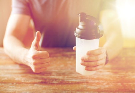 man with protein shake bottle showing thumbs upの写真素材