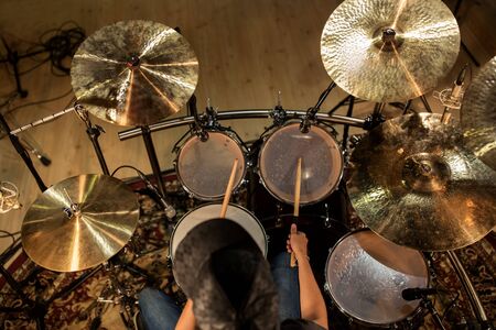 male musician playing drums and cymbals at concertの写真素材