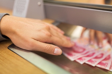 clerk giving cash money to customer at bank officeの写真素材