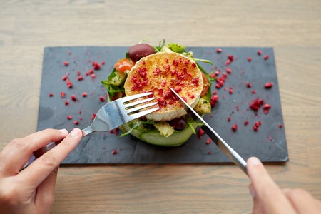 woman eating goat cheese salad at restaurant