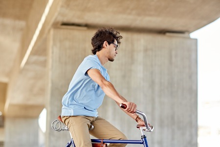 people, style and lifestyle -  hipster man riding fixed gear bike on city streetの写真素材