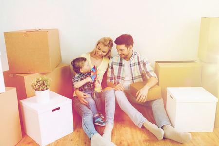 happy family with boxes moving to new homeの写真素材