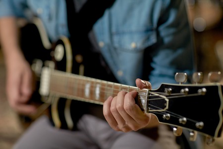 close up of man playing guitar at studio rehearsalの写真素材
