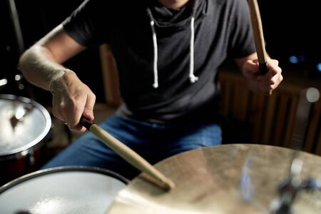 male musician playing drums and cymbals at concertの写真素材