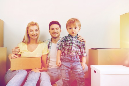 happy family with boxes moving to new homeの写真素材