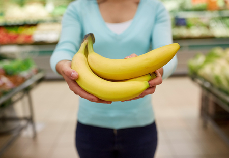 woman with bananas at grocery storeの写真素材