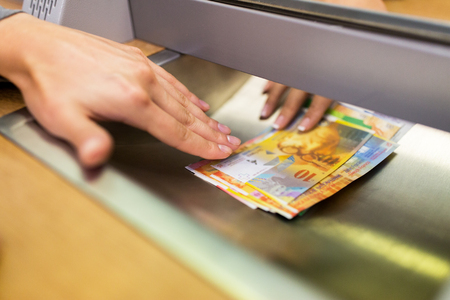 clerk giving cash money to customer at bank officeの写真素材