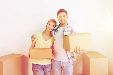 smiling couple with big boxes moving to new homeの写真素材