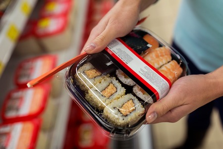 hands with sushi pack at grocery or supermarketの写真素材