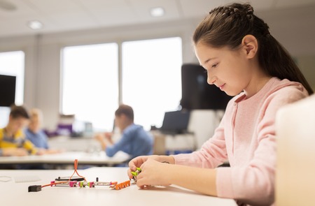 happy girl building robot at robotics schoolの写真素材