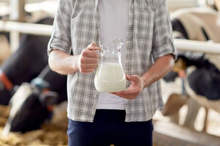 close up of man or farmer with milk on dairy farmの写真素材