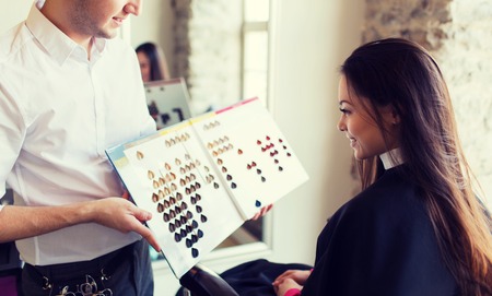 woman choosing hair color from palette at salonの写真素材