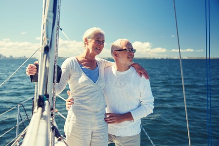 senior couple hugging on sail boat or yacht in seaの写真素材