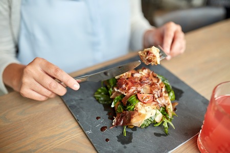 woman eating prosciutto ham salad at restaurantの写真素材
