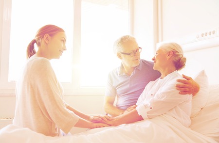 happy family visiting senior woman at hospitalの写真素材