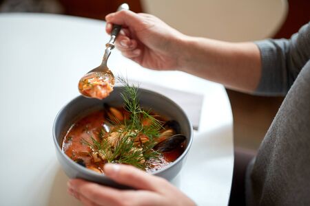 woman eating seafood soup at restaurantの写真素材