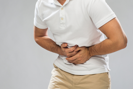 close up of man suffering from stomach acheの写真素材