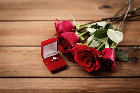 close up of diamond engagement ring and red rosesの写真素材