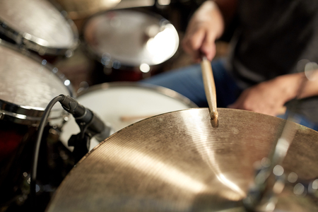 male musician playing drums and cymbals at concert